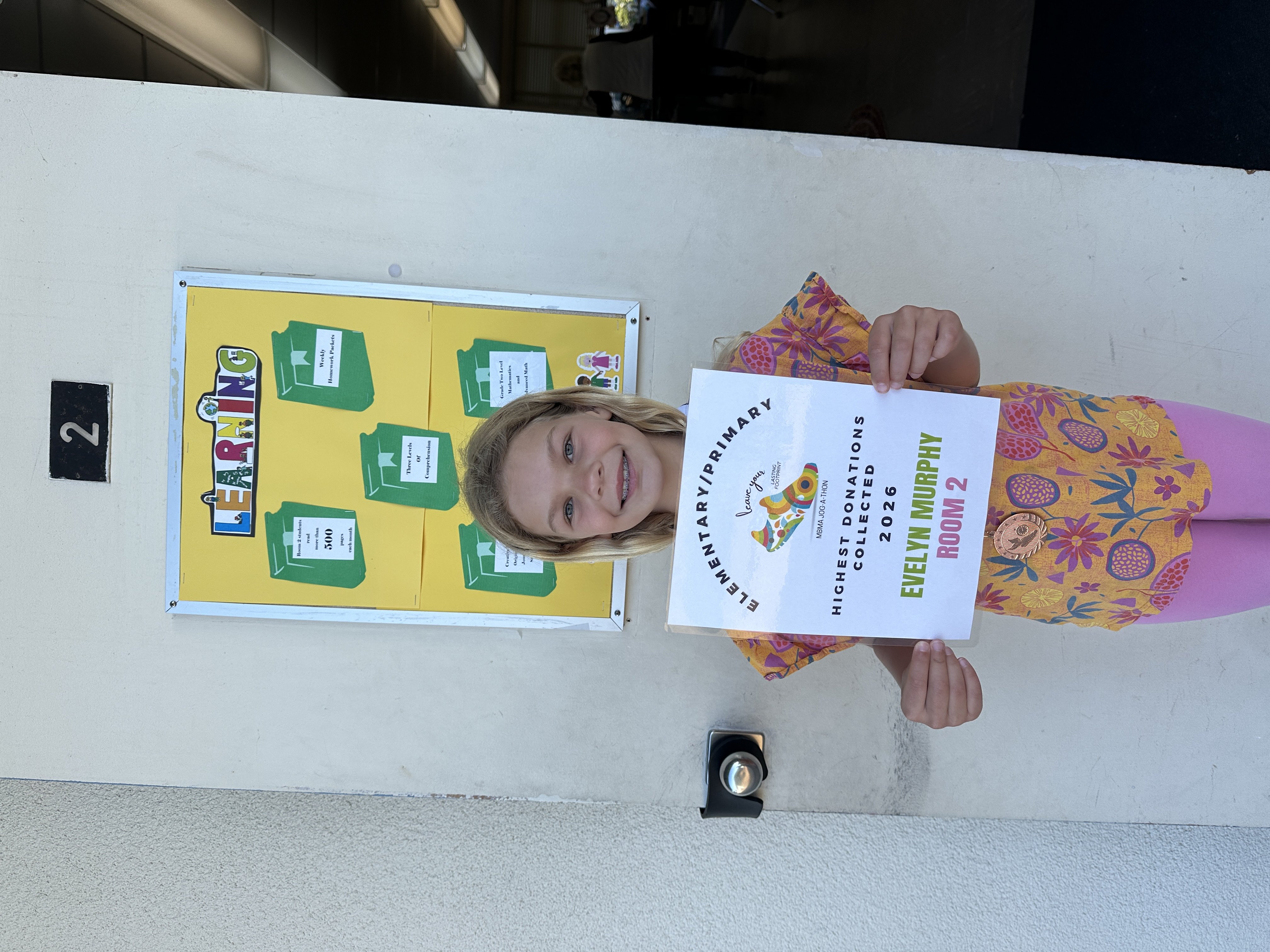 A student holding a Jog-A-Thon award